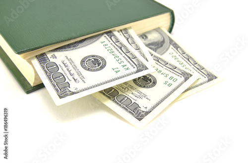 Money embedded in a book on a white background close-up 