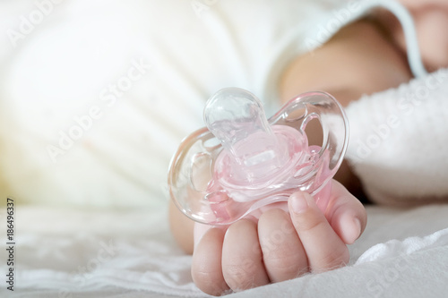 Close up of baby hands with pacifier. Focus is on baby hands photo