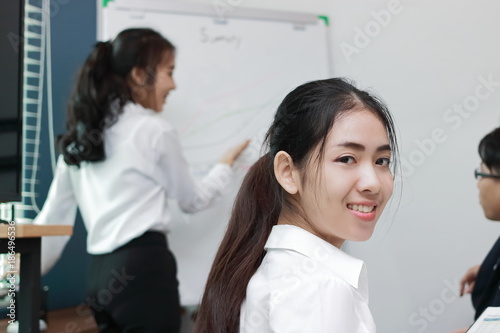 Cheerful young Asian business woman smiling between presentation in office.