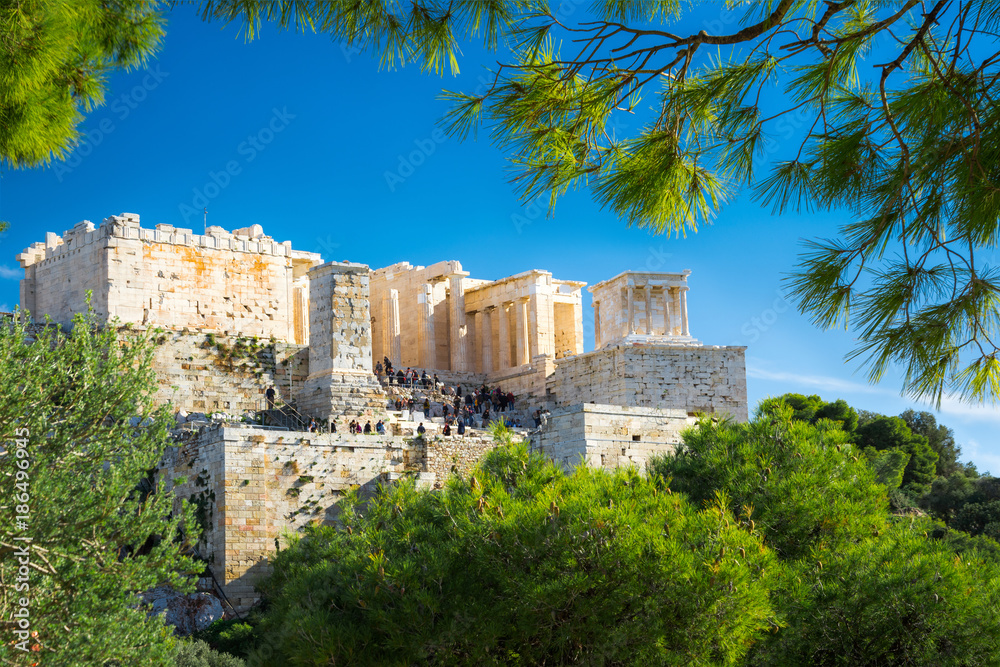 Acropolis with Parthenon. View through a frame of green plants and trees, Athens, Greece.