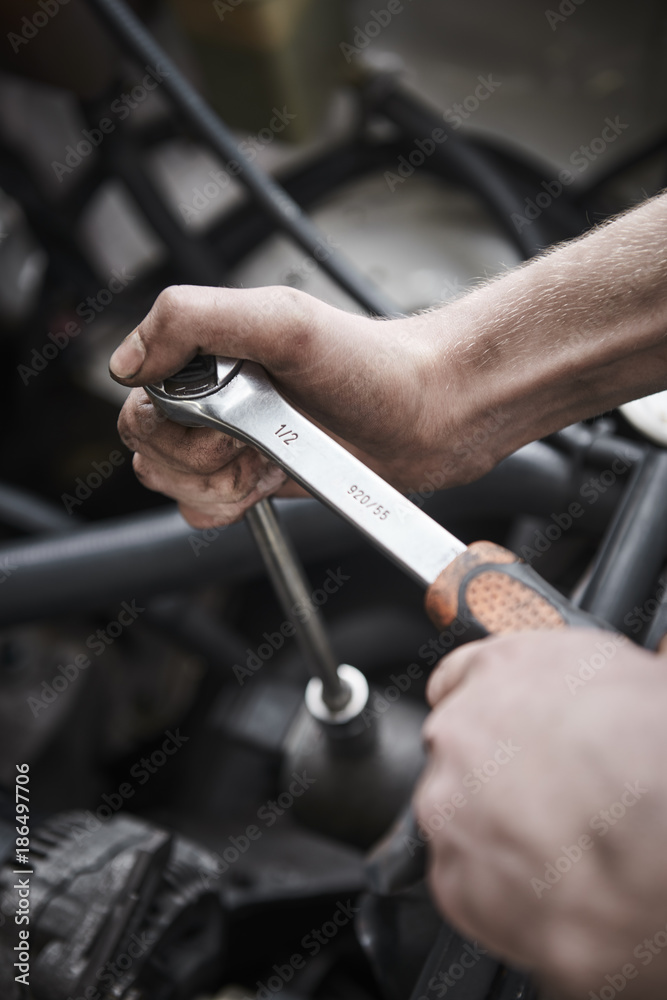 Young mechanic repair a car at a garage Young mechanic repair a car at a garage