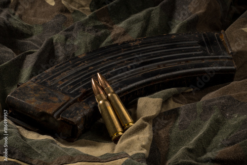 Canvastavla Rusty AK-47 magazine and bullets on camouflage textile background