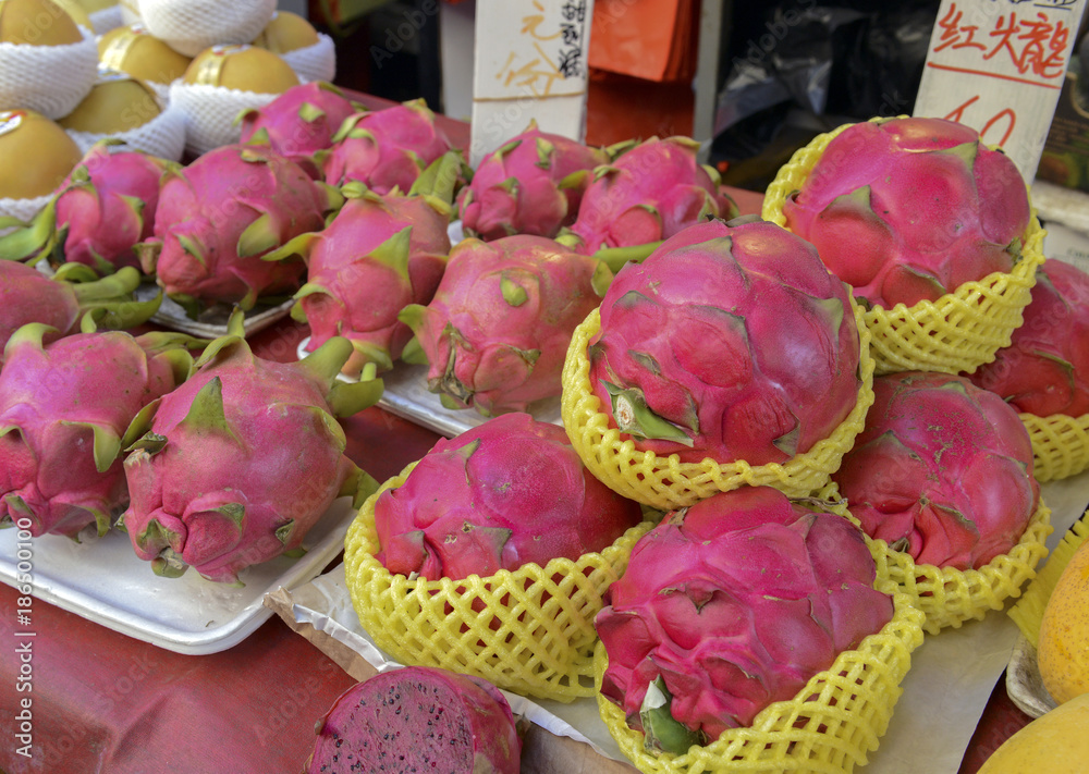 Street food with dragon fruit among various fresh vegetables for sale at Asian market in China Street food with dragon fruit among various fresh vegetables for sale at Asian market in China