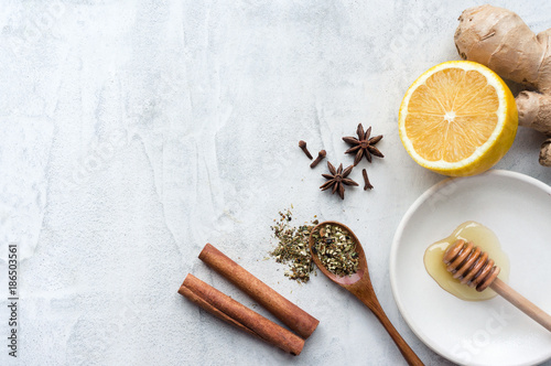 Fotografie Lemon, ginger and spices on concrete background with copy space