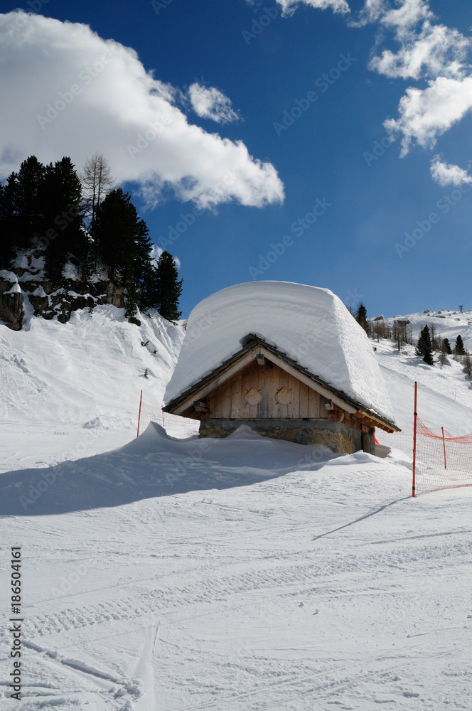 Alpin Hut on the Dolomite Alps with lots of snow on the roof. Winter landscape near the Falzarego Pass, Veneto, italy Alpin Hut on the Dolomite Alps with lots of snow on the roof. Winter landscape near the Falzarego Pass, Veneto, italy