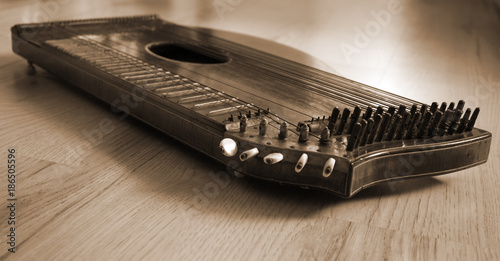 Old zither lying on a wooden table. photo