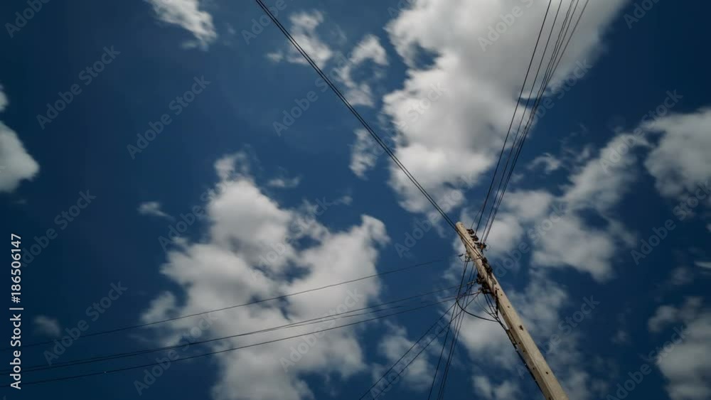 Time lapse clip of white fluffy clouds over blue sky with electric pole
Time lapse clip of white fluffy clouds over blue sky with electric pole
