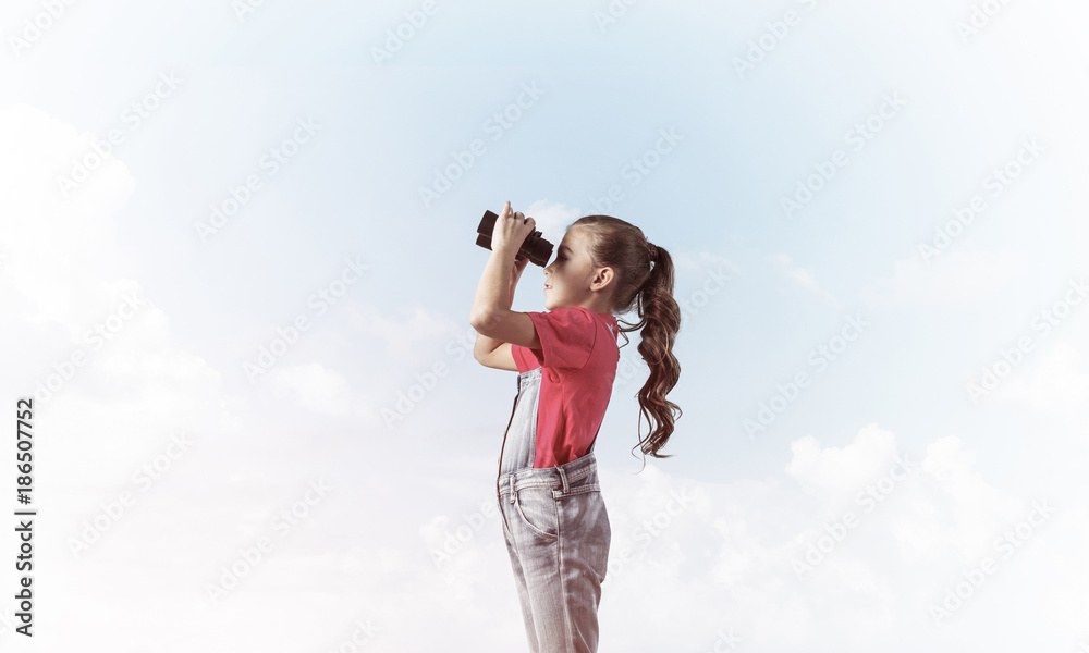 Concept of careless happy childhood with girl looking in binocul