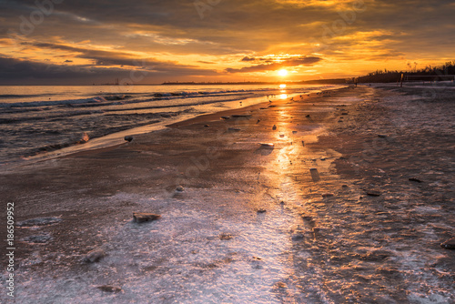 Winter landscape with golden sunrise at the beach in Gdansk in Poland. Baltic Sea.