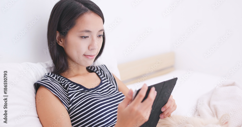 Woman look at tablet computer with her dog