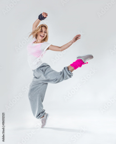 Young beautiful slim girl dancing on a white studio background
