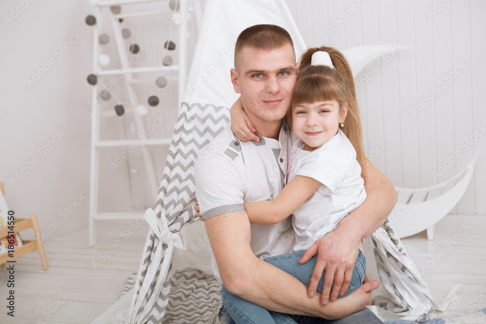 Obraz premium happy daughter hugging father in the kid bedroom. Happy family spending time at home.