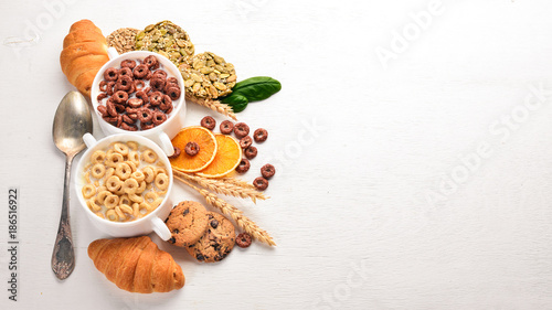 Fitness breakfast, muesli, milk, fruits, nuts and seeds, on a wooden surface. Top view. Free space for text.