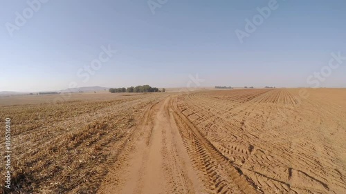 Traveling down rural road between barren fields of corn freshly harvested