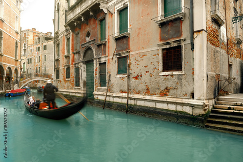 Canal with gondolas in Venice, Italy. Venice in winter time. Tourist having ride in gondolas and canals