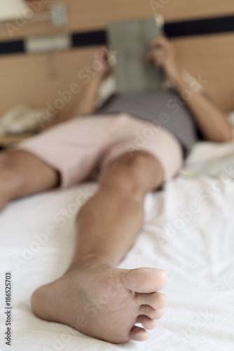 man using a tablet or an e-reader in bed