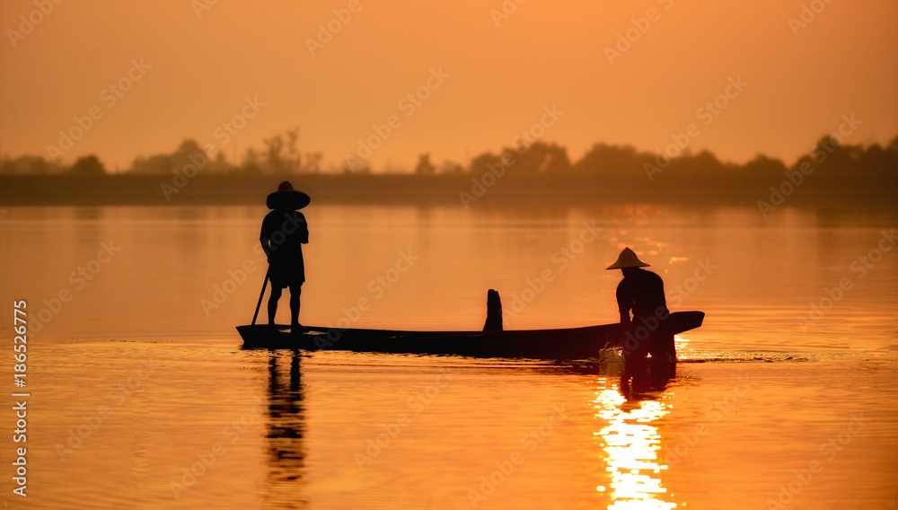 Fisherman on sunset background.