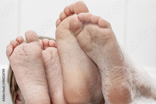 Closeup of wrinkled feet on edge of bubble bath