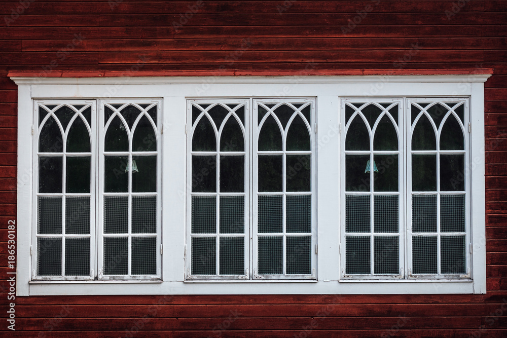 Beautiful tripple white windows on a red wooden building Beautiful tripple white windows on a red wooden building