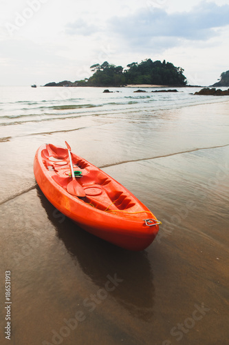 Red kayak at the beach in sunset.