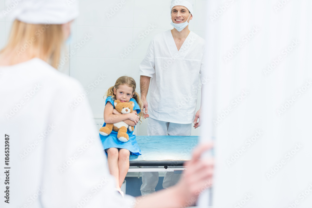 Obraz premium doctors preparing scared kid for surgery in operating room