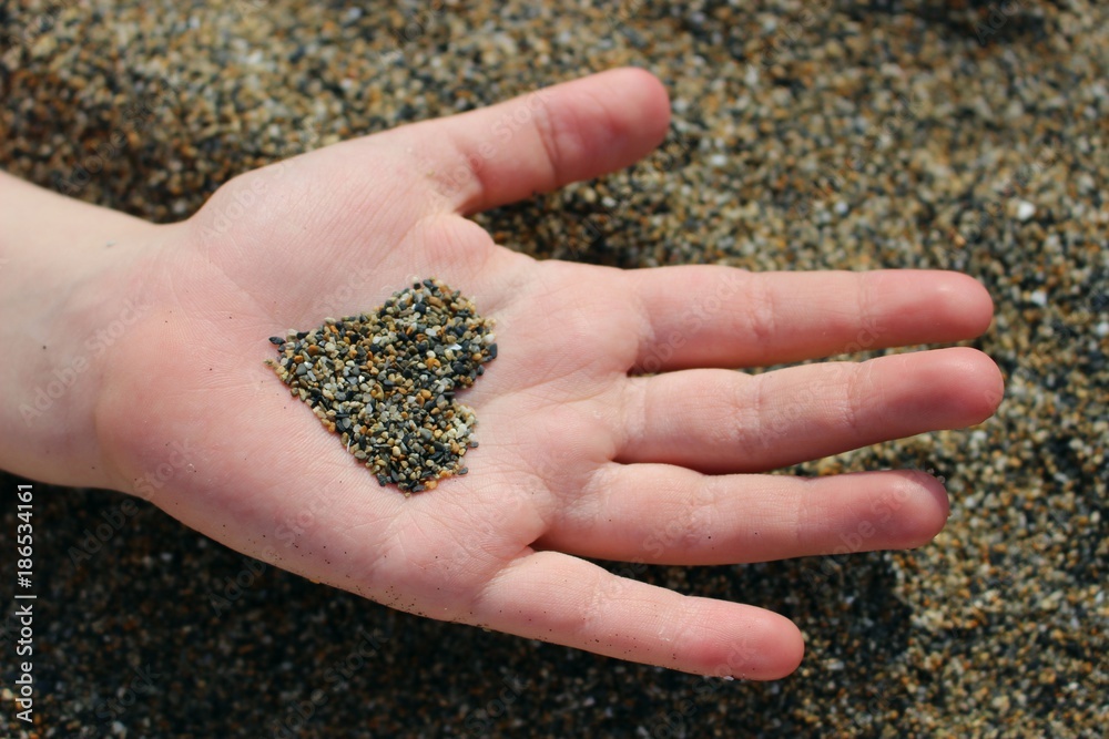 Mellow heart on child hand above beach. Sand heart in someone hand. Pretty small kid holds a heart shape from sand. I love you Mom, Mothers or fathers Day with young kids hand with sand shape. Mellow heart on child hand above beach. Sand heart in someone hand. Pretty small kid holds a heart shape from sand. I love you Mom, Mothers or fathers Day with young kids hand with sand shape.