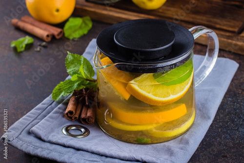 Step by step recipes of citrus tea. Winter Healthy Cold Drink with orange, lemon, cinnamon, mint, anise star and carnation on dark table nbackground. photo