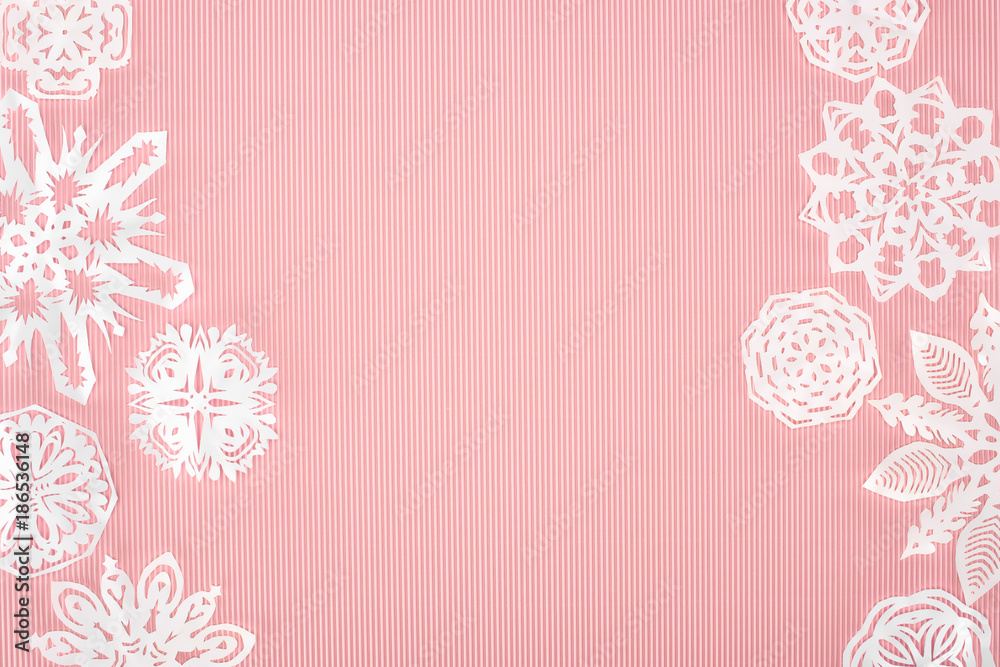 christmas background with paper snowflakes on pink