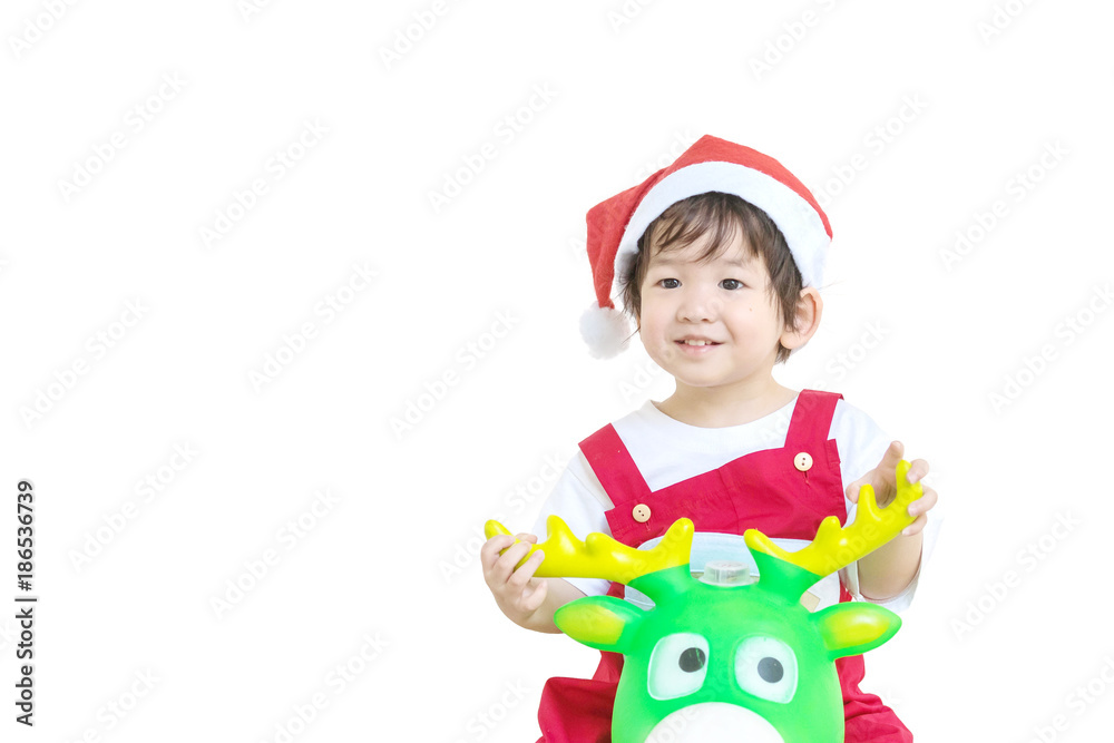 Closeup happy asian kid in santa costume riding reindeer toy isolated on white background in christmas concept Closeup happy asian kid in santa costume riding reindeer toy isolated on white background in christmas concept
