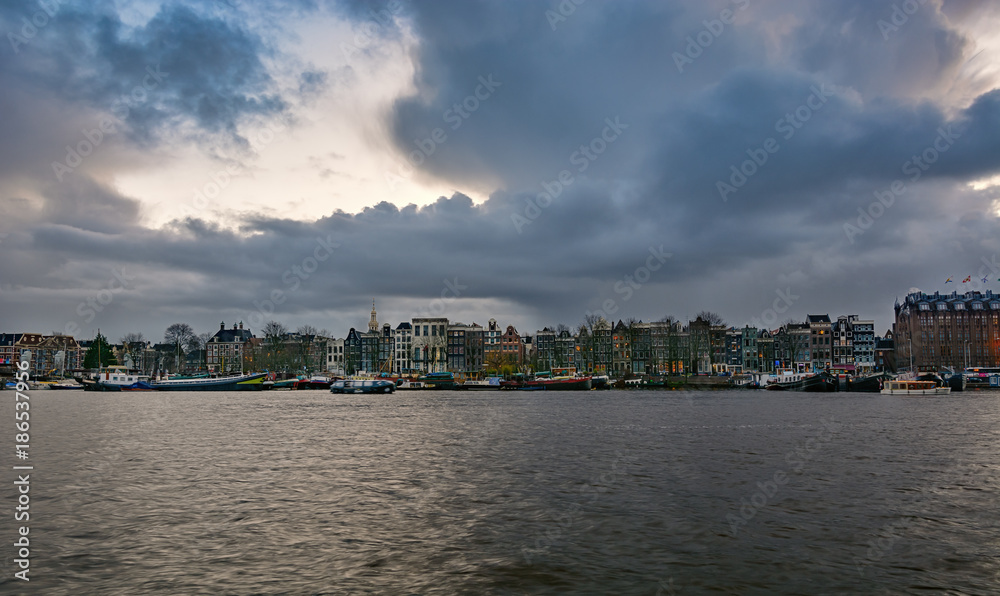 The characteristic canal houses and moored ships along the Oosterdok canal in the old town of Amsterdam