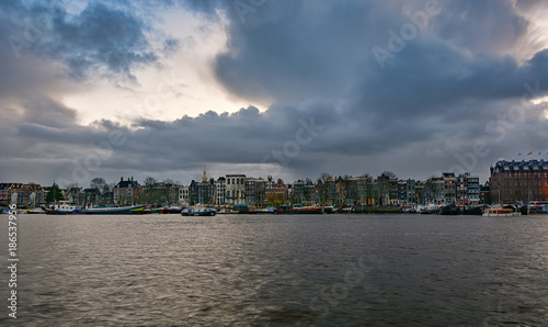 The characteristic canal houses and moored ships along the Oosterdok canal in the old town of Amsterdam