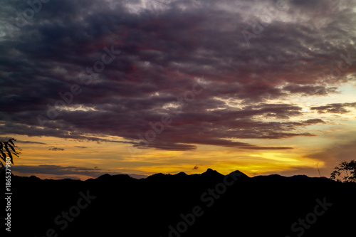 The ridge is a black silhouette. Sunset time. Use as background.