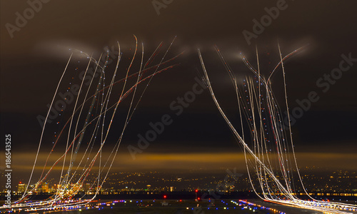 Light paintings over airport against cloudy sky in city at night photo