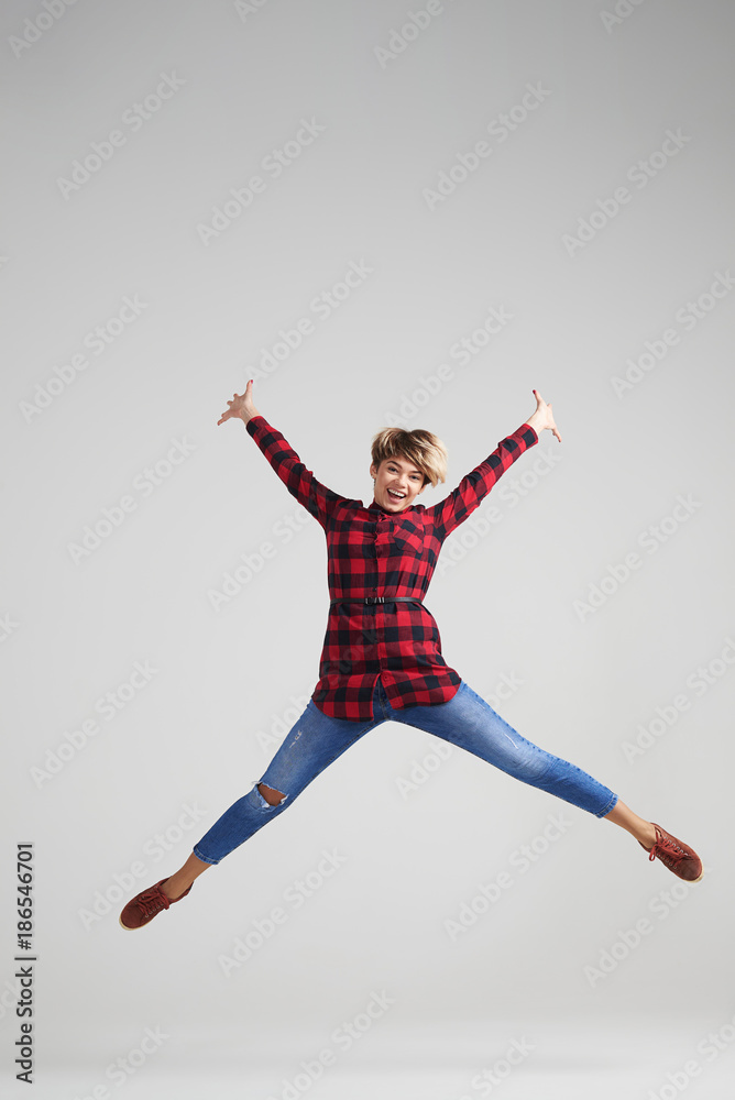 Positive woman jumping in excitement at studio