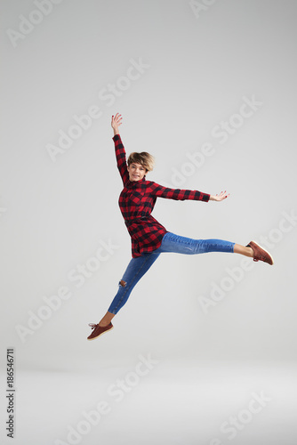 Young energetic girl jumping at studio
