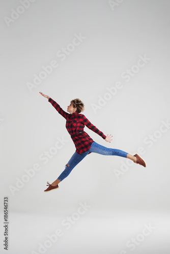 Sporty girl doing splits in the air at studio
