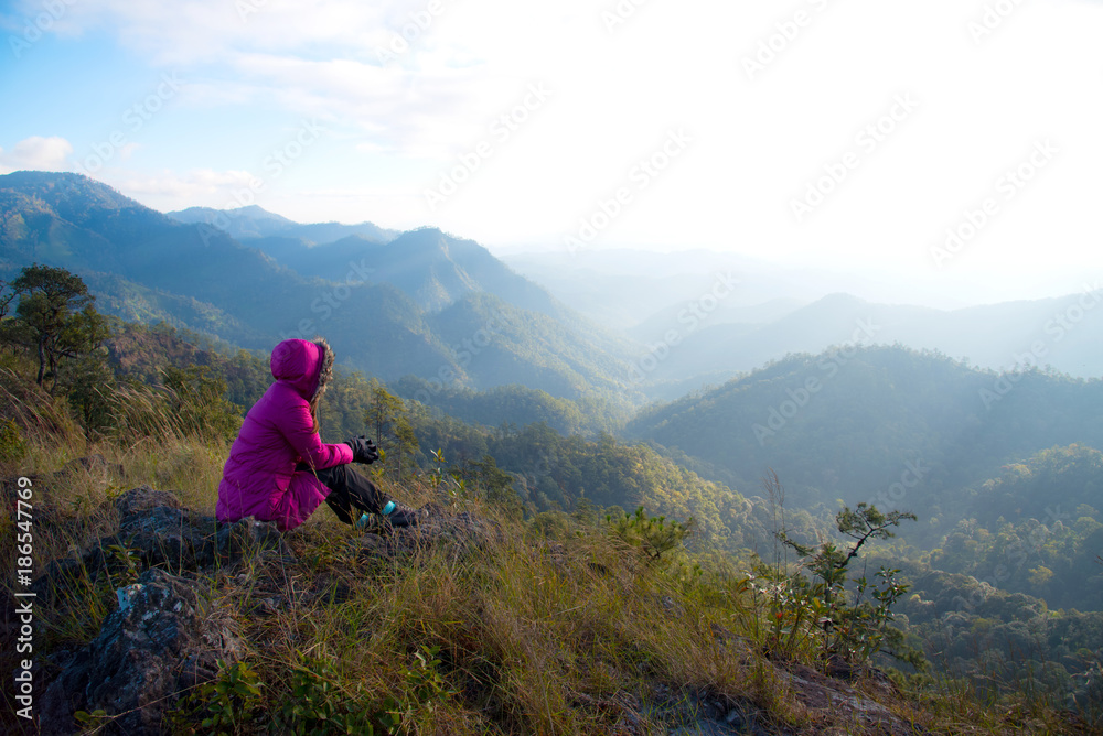 Fototapeta premium Woman tourism vacation and travel. Tourist woman in camping site sitting and enjoying mountains landscape at winter mountain in Chiangmai, Thailand. 