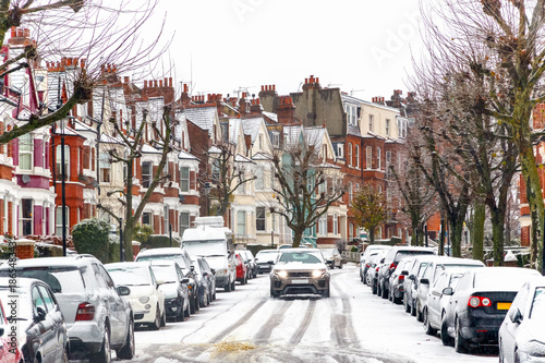Car driving through a terraced street covered with snow around West Hampstead area in London