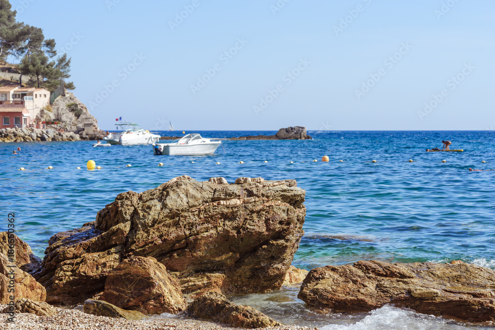 rocky sea shore with pebble beach, waves , blue sky