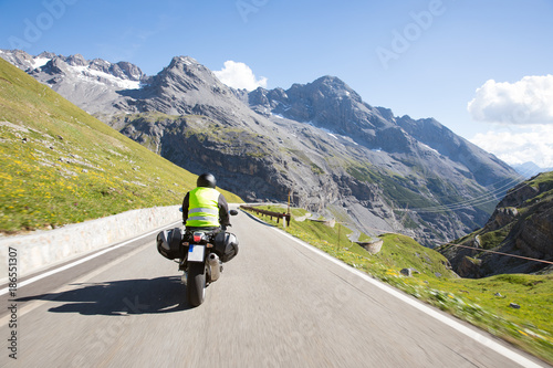 Motorradfahrer f  hrt mit seinem Motorrad auf kurvigen Stra  en durch die Berge und einer wundersch  ne Landschaft