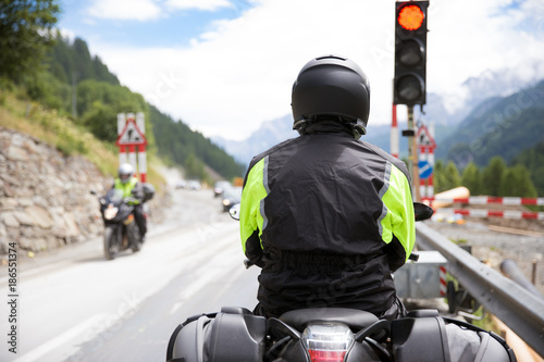 Motorbiker is riding his motorcycle on winding roads through the mountains an beautiful landscape