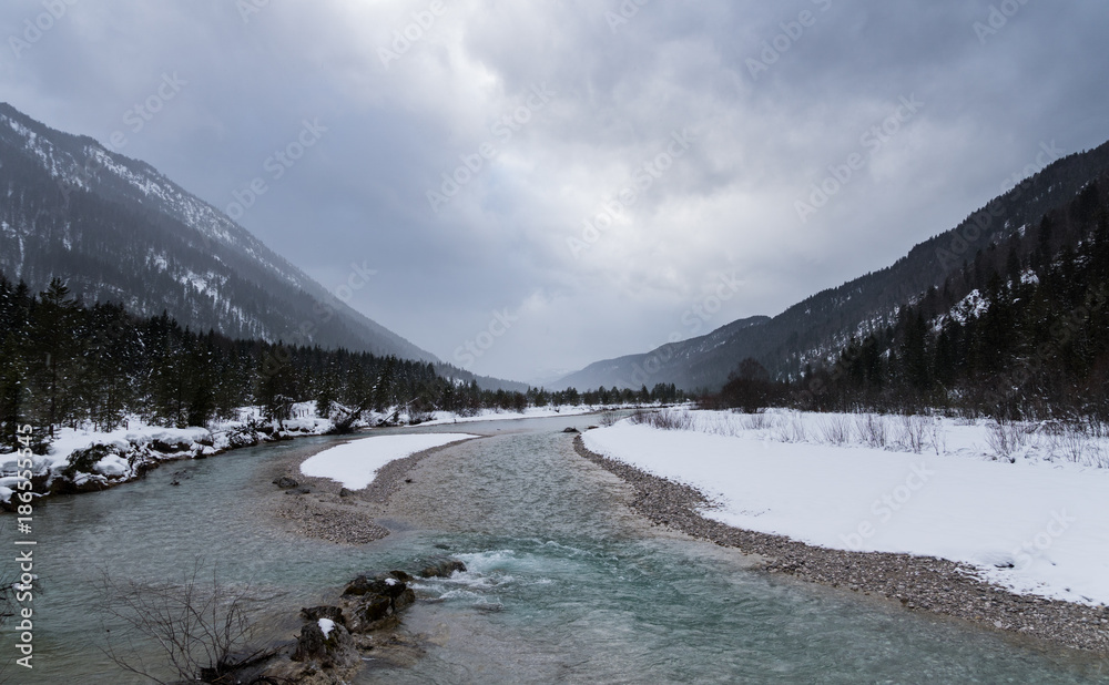 Fluss mit flachem Ufer und wolkigem Hintergrund