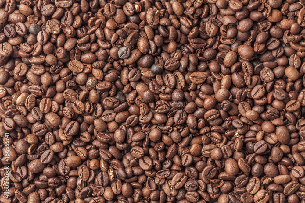 Background with organic spilled arabica coffee in beans