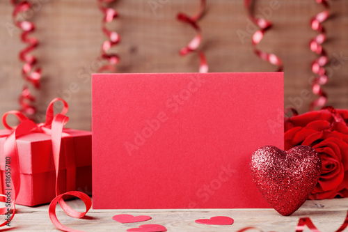 Valentines day mockup. Red heart, paper card and gift on wooden table.