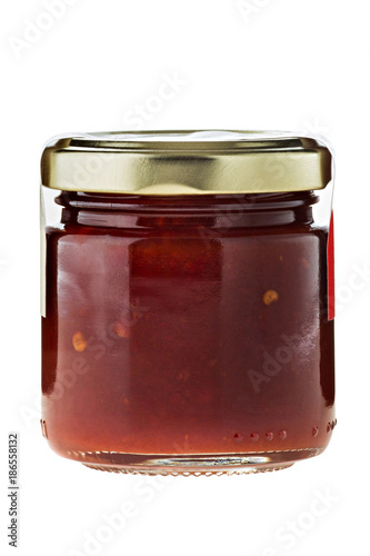 Hot chili sauce in glass on white background