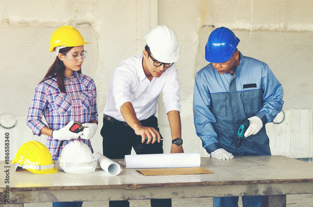 Engineer group and worker meeting, discussion with construction blueprint on site work and point finger to the blueprint. Engineer group and worker meeting, discussion with construction blueprint on site work and point finger to the blueprint.
