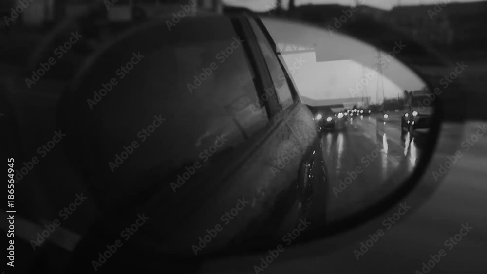 Drunk driver looking through rearview mirror on a rainy day Drunk driver looking through rearview mirror on a rainy day