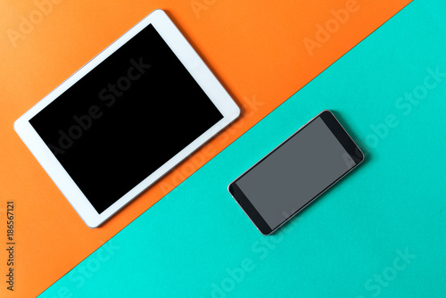 tablet and smart phone on orange green paper background