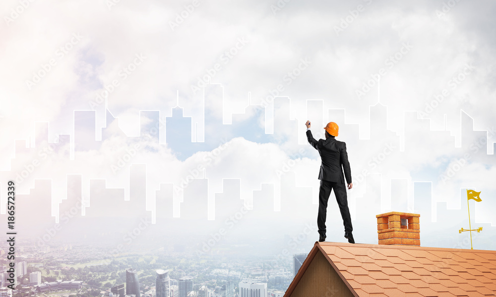 Man architect draw silhouette of modern city on blue sky. Mixed media Man architect draw silhouette of modern city on blue sky. Mixed media