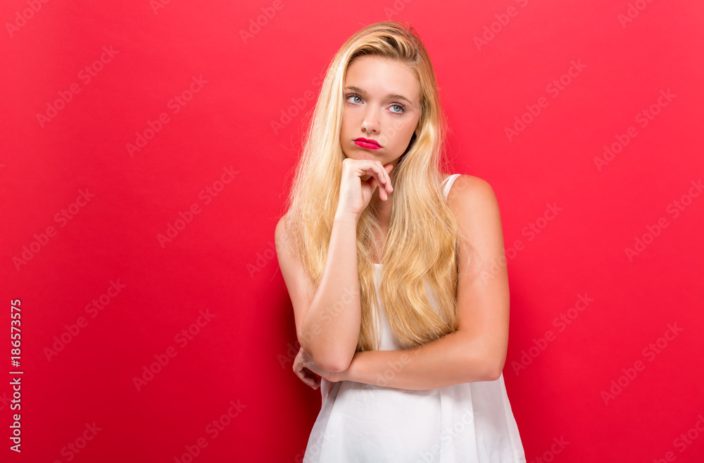 Young woman in a thoughtful pose on a solid background Young woman in a thoughtful pose on a solid background